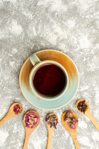 Foto gratuita vista superior de la taza de té con flores secas en la superficie blanca bebida de sabor a flor de té