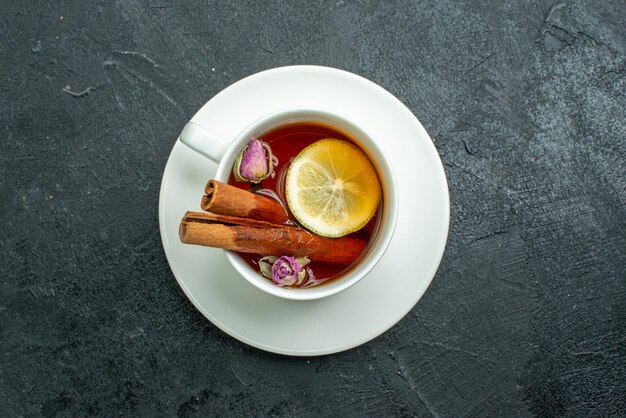 Vista superior de una taza de té con flores y té en la superficie oscura de la ceremonia de los cítricos de frutas de té