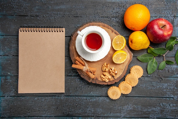 Vista superior de una taza de té con frutas y galletas