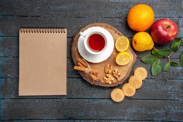 Vista superior de una taza de té con frutas y galletas