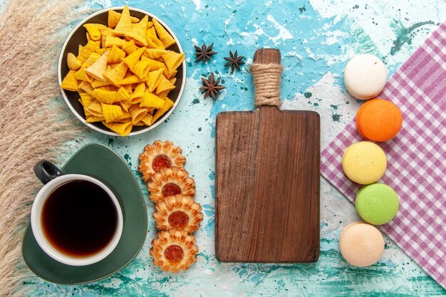 Vista superior de la taza de té con galletas de azúcar y macarons sobre fondo azul claro galleta galleta azúcar pastel de té dulce pastel