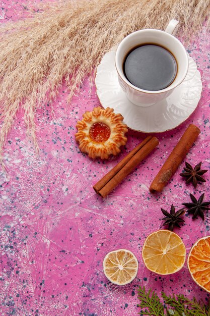 Vista superior de la taza de té con galletas y canela sobre fondo rosa color té galleta dulce