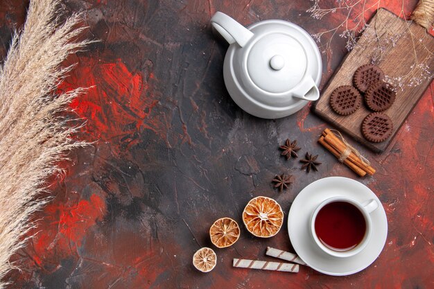 Vista superior de la taza de té con galletas choco en la galleta de té de escritorio oscuro