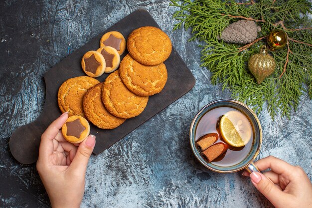 Vista superior de la taza de té con galletas dulces en el fondo claro