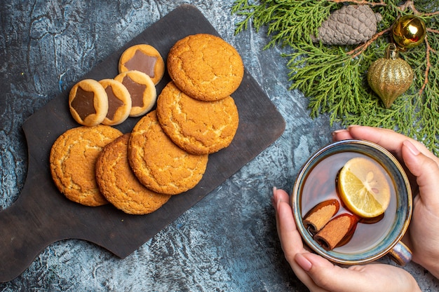 Vista superior de la taza de té con galletas dulces en el fondo claro