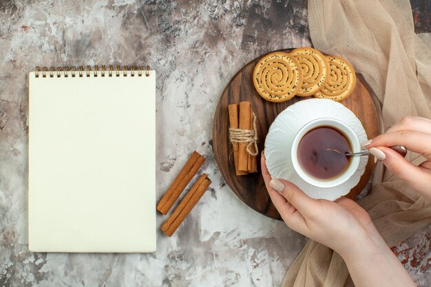 Vista superior taza de té con galletas dulces sobre un fondo claro ceremonia de color pastel café azúcar romper galleta