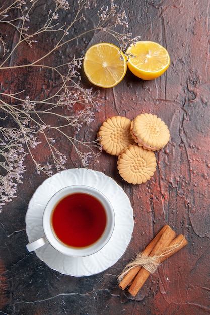 Vista superior de la taza de té con galletas en la mesa oscura azúcar té foto galleta dulce