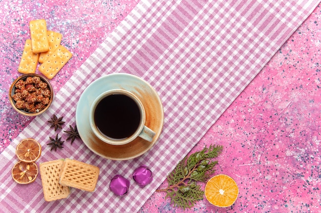 Vista superior de la taza de té con gofres y galletas en rosa