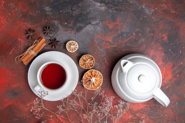 Vista superior de la taza de té con hervidor de agua en la mesa oscura