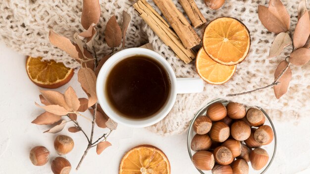 Vista superior de la taza de té con hojas de otoño y ramitas de canela