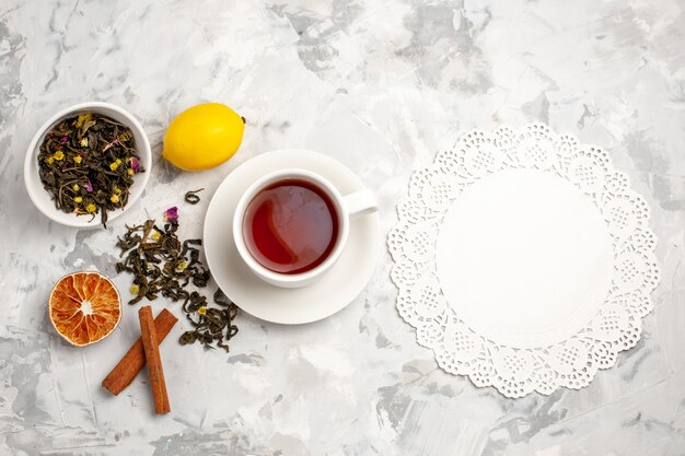 Vista superior de una taza de té con limón y canela en un espacio en blanco