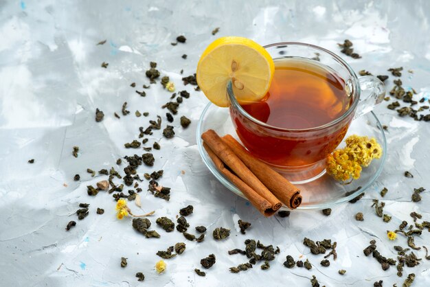 Vista superior de una taza de té con limón y canela en una fruta líquida de té brillante