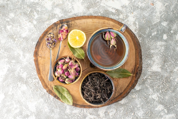 Vista superior taza de té con limón y flores sobre fondo claro desayuno ceremonia sabor fruta color flor de la mañana