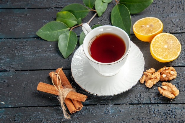 Vista superior de la taza de té con limón en la mesa oscura, azúcar de tarta de galleta dulce