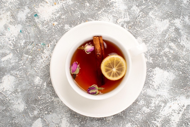 Vista superior de la taza de té con limón sobre superficie blanca