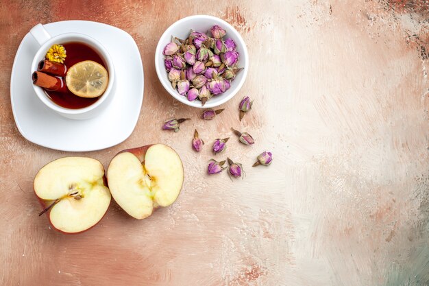 Vista superior de la taza de té con manzanas y flores en la mesa de luz flor de té de frutas