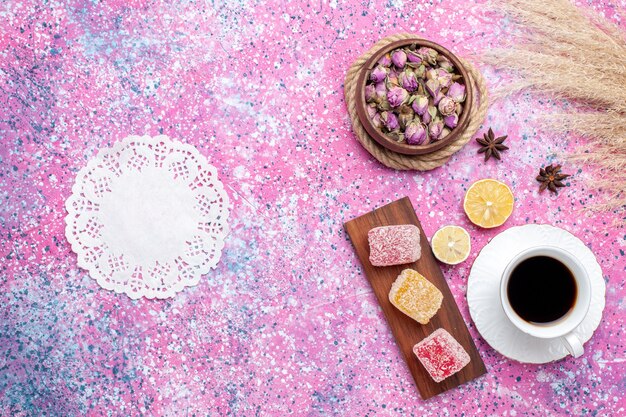 Vista superior de la taza de té con mermelada sobre fondo rosa.