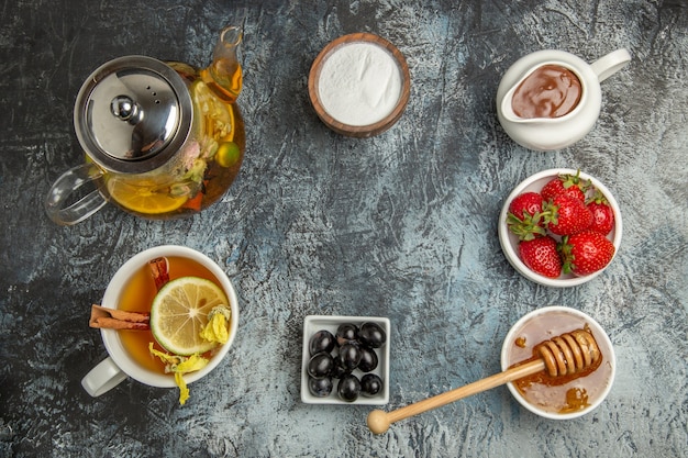 Vista superior de la taza de té con miel y frutas en té de frutas dulces de superficie ligera