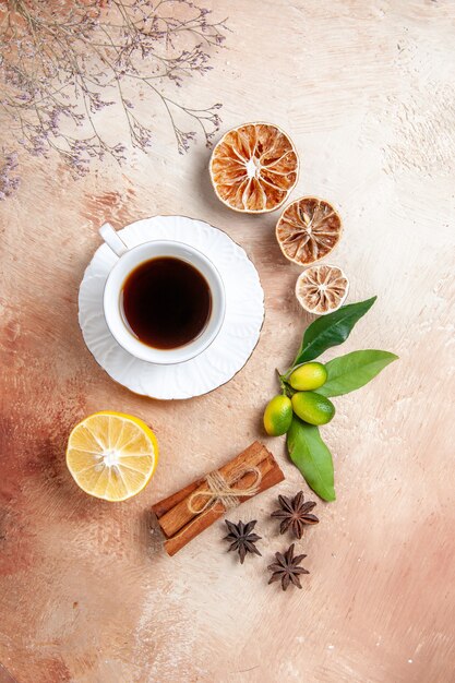 Vista superior de una taza de té negro con limones y canela en rama