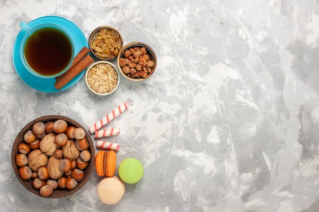 Vista superior de la taza de té con nueces taza de té y pasas en la superficie blanca