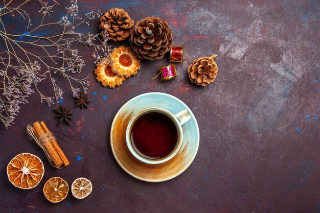 Vista superior de la taza de té con pequeñas galletas sobre fondo oscuro galleta de azúcar galleta dulce