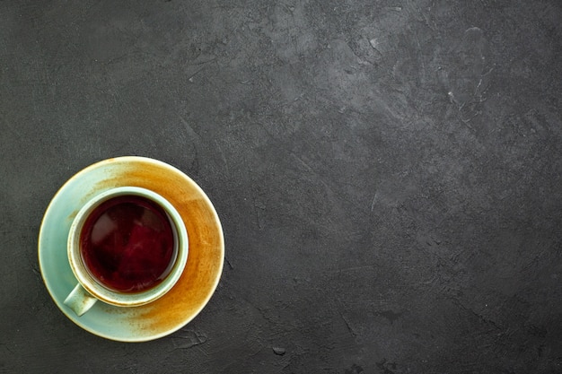 Vista superior de una taza de té en un plato pequeño