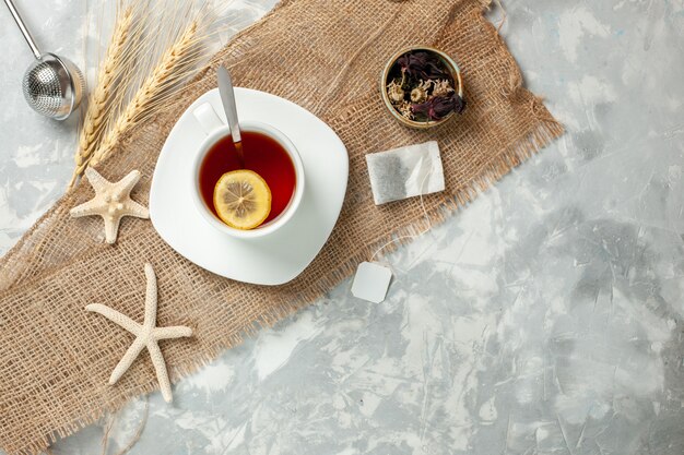 Vista superior de la taza de té con una rodaja de limón en la pared blanca bebida de té fruta limón