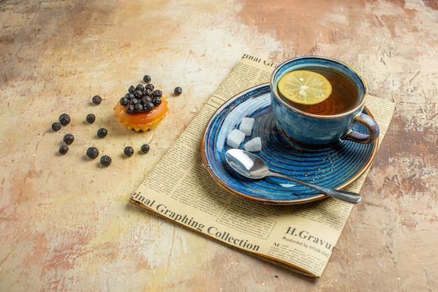 Vista superior de una taza de té con una rodaja de limón sobre el fondo claro