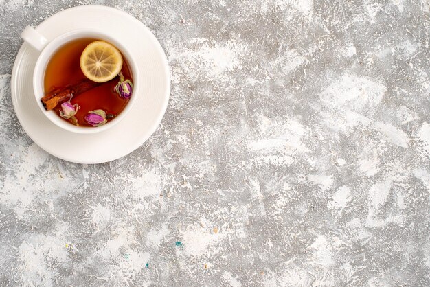 Vista superior de la taza de té con una rodaja de limón en la superficie blanca