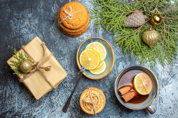 Foto gratuita vista superior de la taza de té con rodajas de limón y galletas en el escritorio de luz color galleta foto de navidad año nuevo