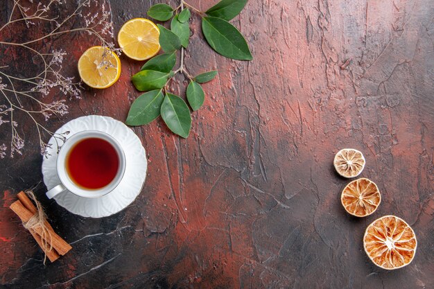 Vista superior de la taza de té con rodajas de limón en la mesa oscura azúcar té foto galleta dulce