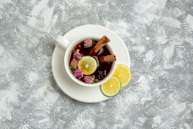 Vista superior de la taza de té con rodajas de limón sobre fondo blanco, bebida de té, desayuno de azúcar dulce caliente