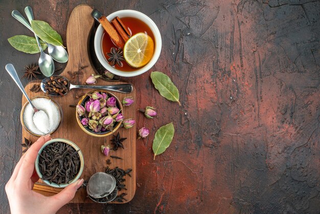 Vista superior taza de té con té negro y flores secas en el fondo marrón oscuro té agua color desayuno foto bebida ceremonia galleta