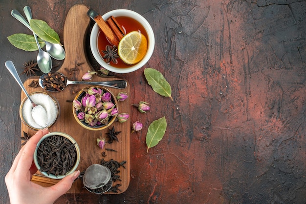 Vista superior taza de té con té negro y flores secas en el fondo marrón oscuro té agua color desayuno foto bebida ceremonia galleta