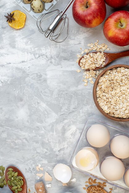 Vista superior tazón de avena huevos en viola cuchara de madera manzanas en la mesa con lugar de copia