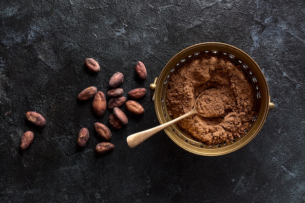 Vista superior del tazón con cacao en polvo y granos de cacao