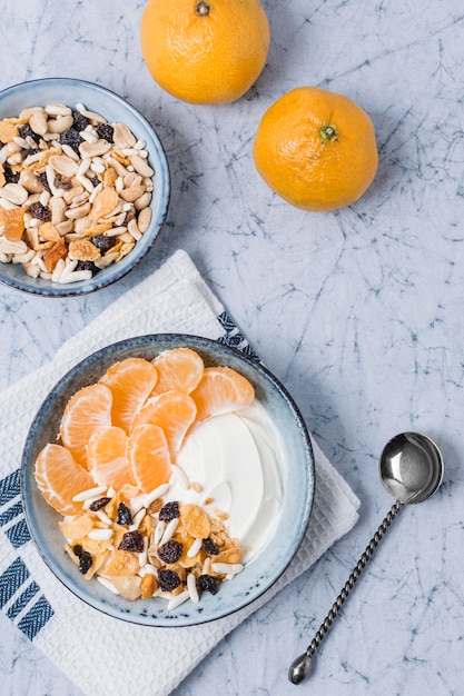 Vista superior del tazón de desayuno con naranja y yogurt