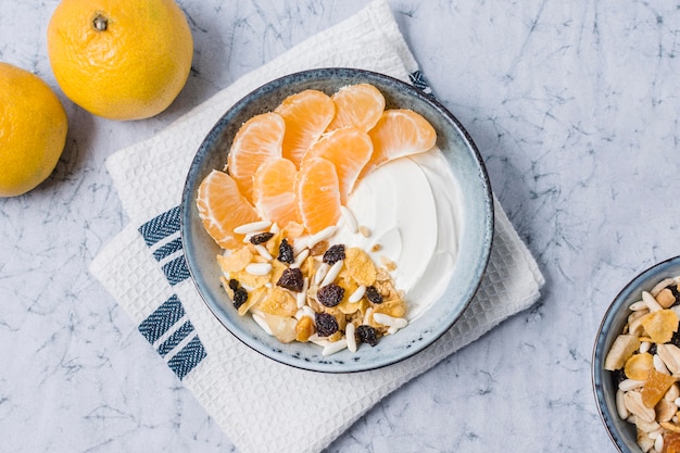 Foto gratuita vista superior del tazón de desayuno con yogur y naranja