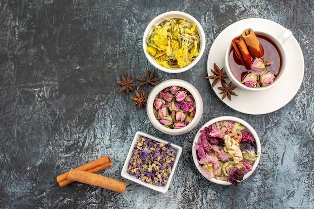 Foto gratuita vista superior de té de hierbas con canela y flores secas sobre fondo gris