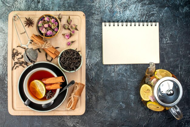 Vista superior té de limón en taza y tetera en el fondo gris mañana fruta desayuno ceremonia color foto comida