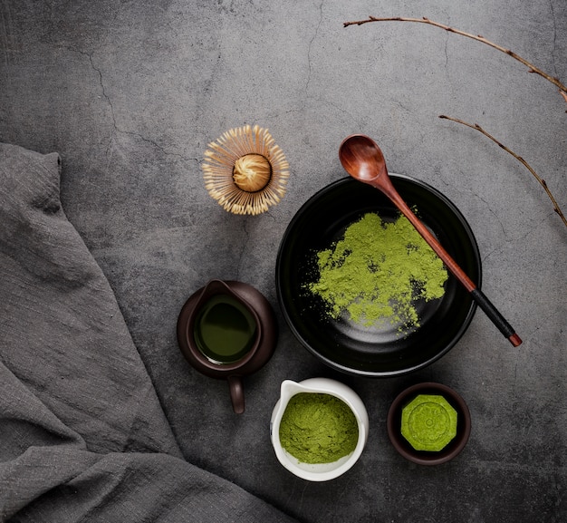 Vista superior de té matcha con ramas y cuchara de madera