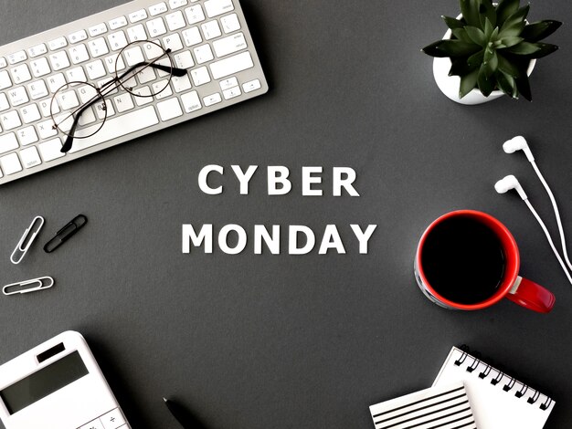 Vista superior del teclado con café y vasos para el cyber monday