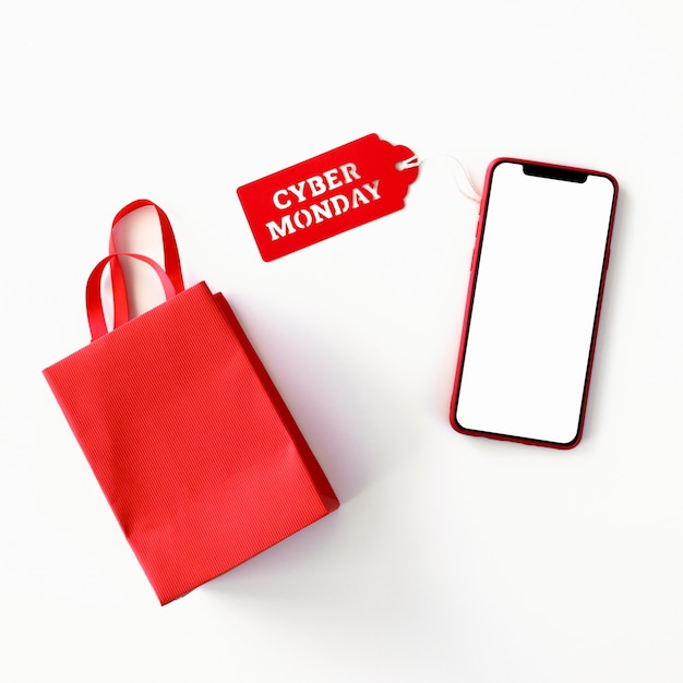 Vista superior del teléfono inteligente con bolsa de compras y etiqueta de cyber monday