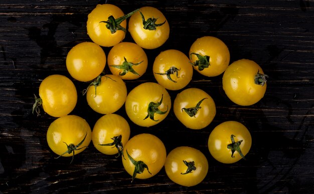 Vista superior de tomates amarillos en mesa de madera