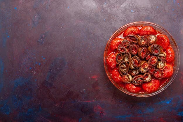 Vista superior de tomates y berenjenas de comida vegetal cocida en el escritorio oscuro