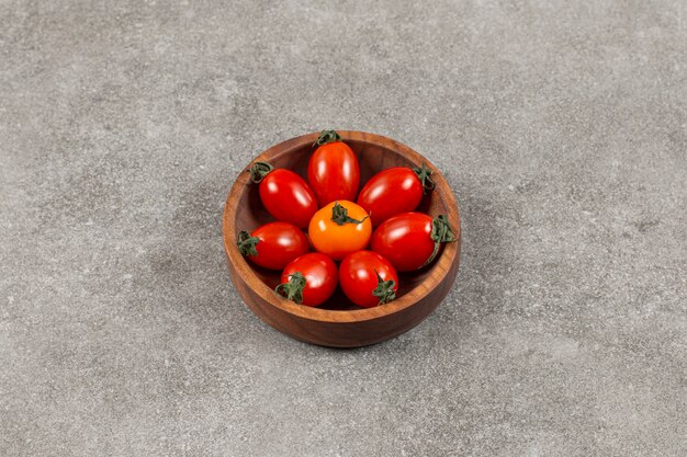 Vista superior de tomates cherry frescos en un tazón de madera.