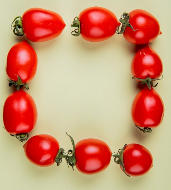 Foto gratuita vista superior de tomates en forma cuadrada sobre superficie amarilla con espacio de copia