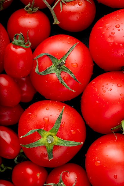 Foto gratuita vista superior de tomates frescos maduros con gotas de agua sobre fondo negro