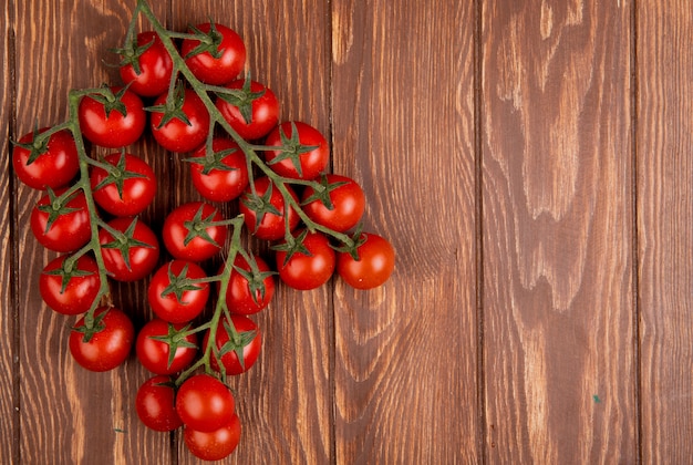 Vista superior de tomates en el lado izquierdo y madera con espacio de copia