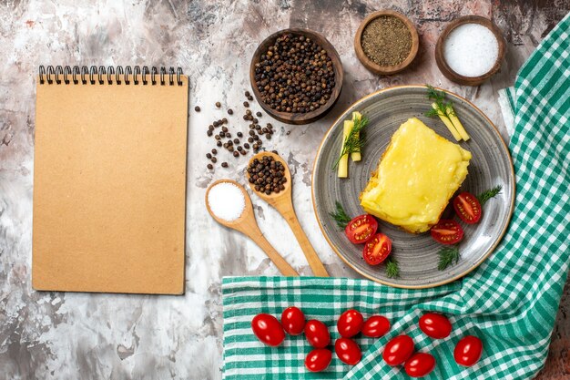 Vista superior de tomates de pan con queso en un plato de diferentes especias en tazones de notas de cucharas de madera en nude